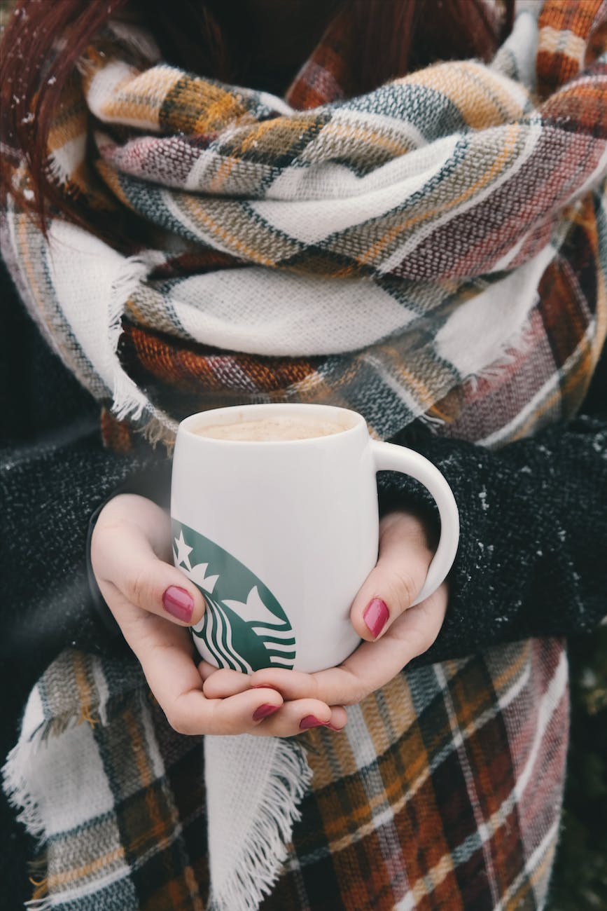 person holding white starbucks mug