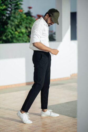 man in white t-shirt and black pants standing on white floor